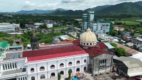 Orbiting-Aerial-View-of-Cathedral-Church-in-center-of-busy-downtown-Virac,-Catanduanes