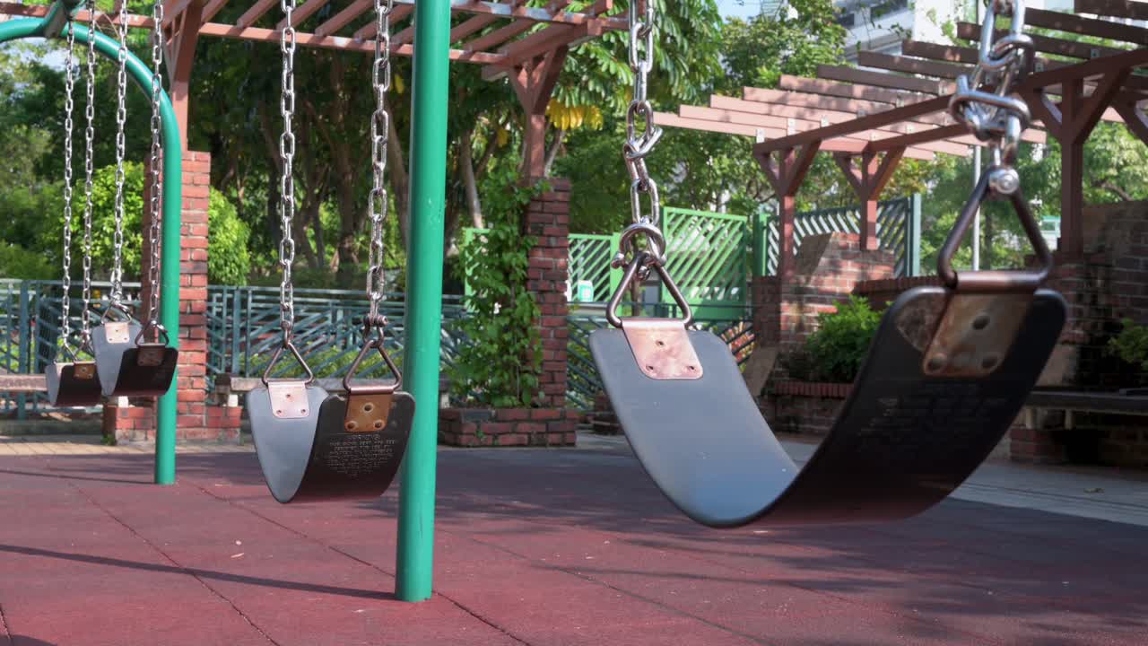 A row of empty swings on a children's playground at a park in Hong Kong