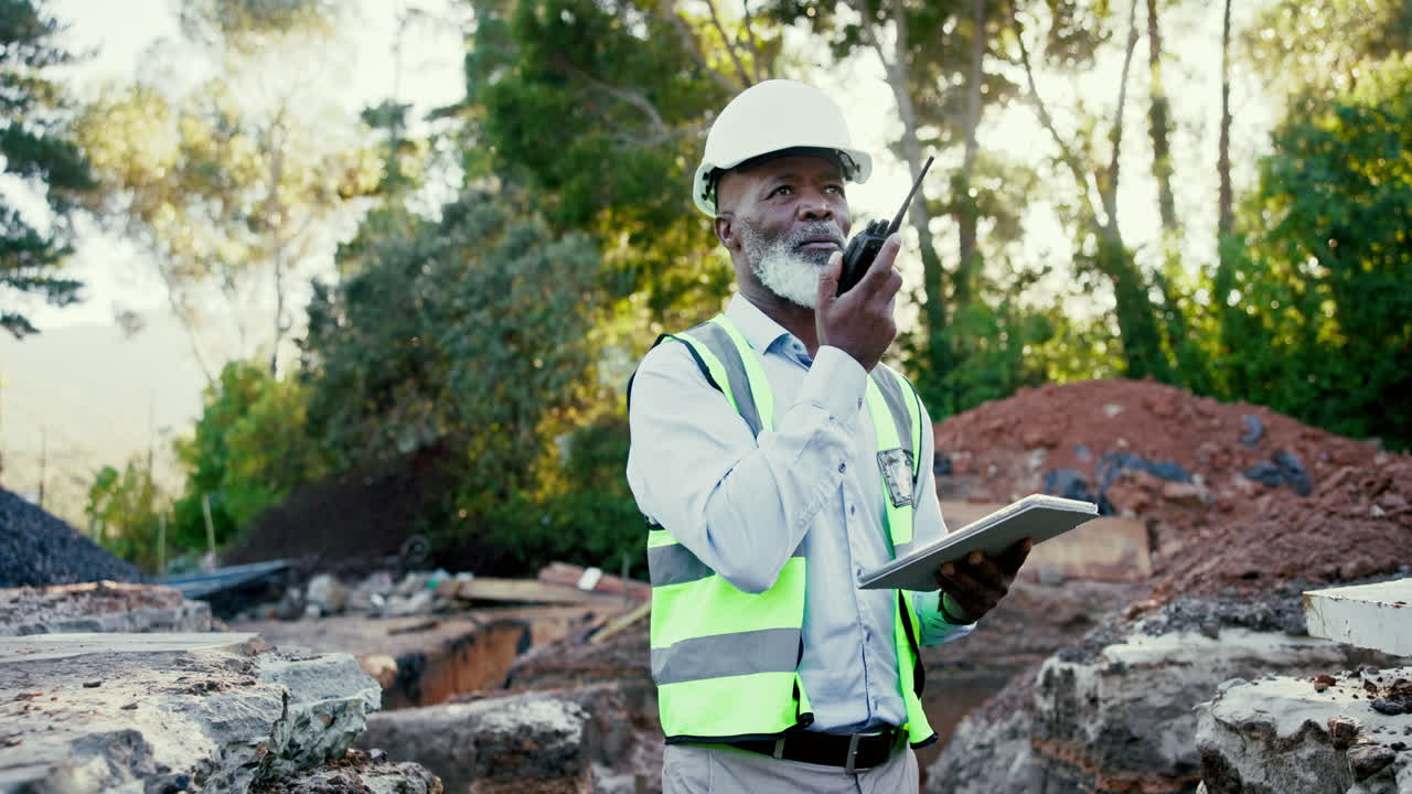 Construction worker using walkie-talkie and tablet on site