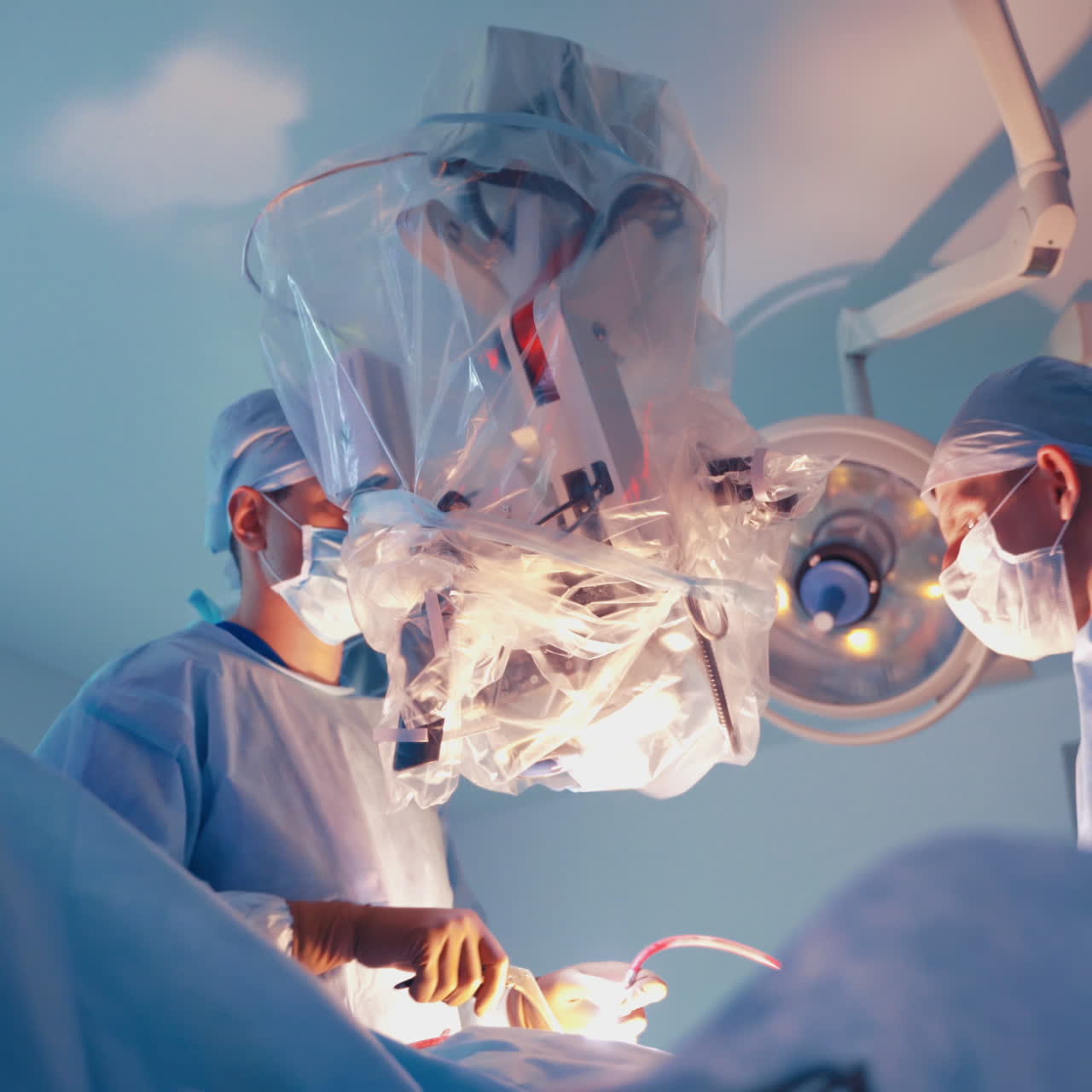 Professional doctors making operation. Two surgeons performing surgery using medical instruments. Modern microscope for surgery.