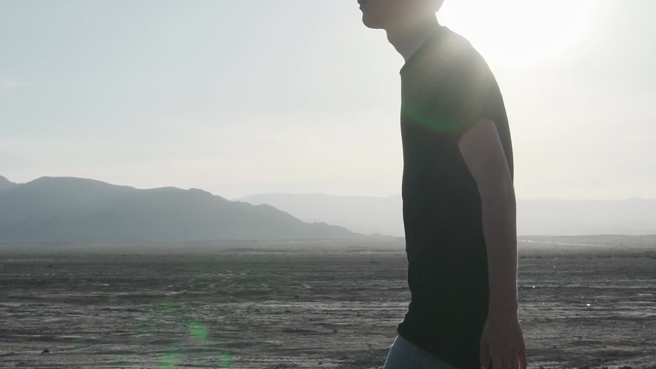 man walking through the desert on a sunny day