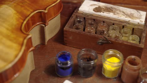 Pigments-and-oils-on-workbench-in-luthiery