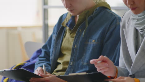 people in a meeting, taking notes