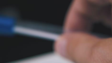 person shakes pen in transparent case on dark background