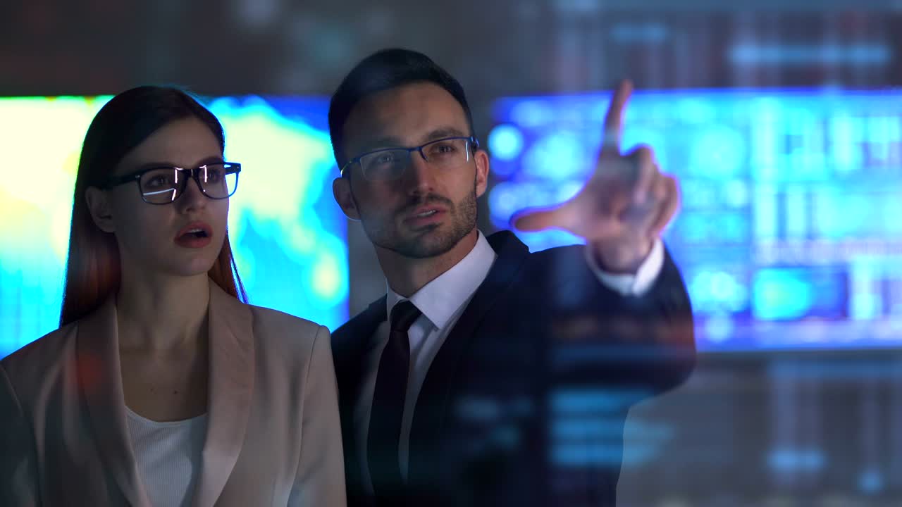 The woman and a man working with a virtual display on the hologram background