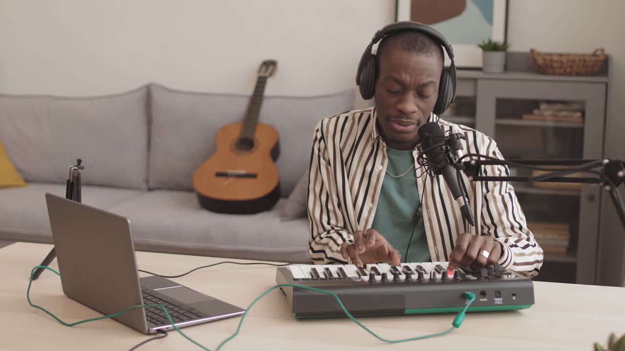 Man playing keyboard with laptop and microphone