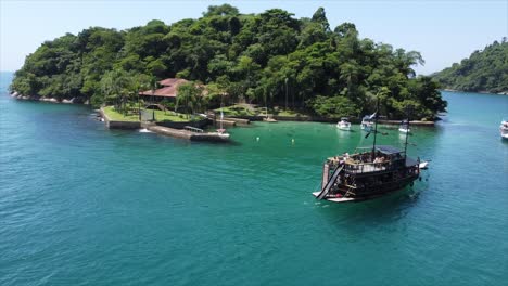 pirate ship tour pulling up to tropical island in brazil's atlantic ocean