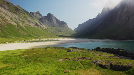 revealing drone shot of horseid beach with turquoise blue water, clouds moving over cliffs