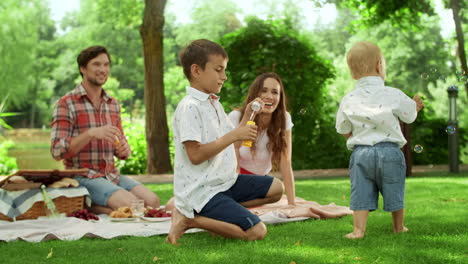 happy man and woman spending weekend with children in forest