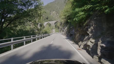 Driving-on-a-narrow-mountain-road-in-a-forest-in-the-Italian-Alps