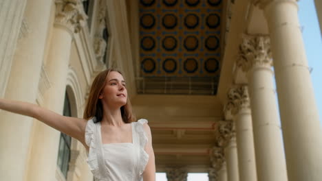 young woman posing in front of classical architecture