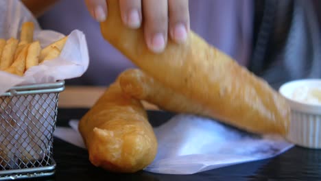 persona comiendo pescado y papas fritas con papas fritas