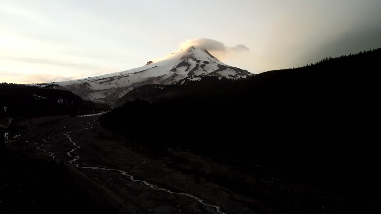 US, Oregon, Mt Hood, , 2025-05-10 - Drone view of Mt Hood in northern Oregon at sunset with clouds curling over the peak of the mountain in the Spring.