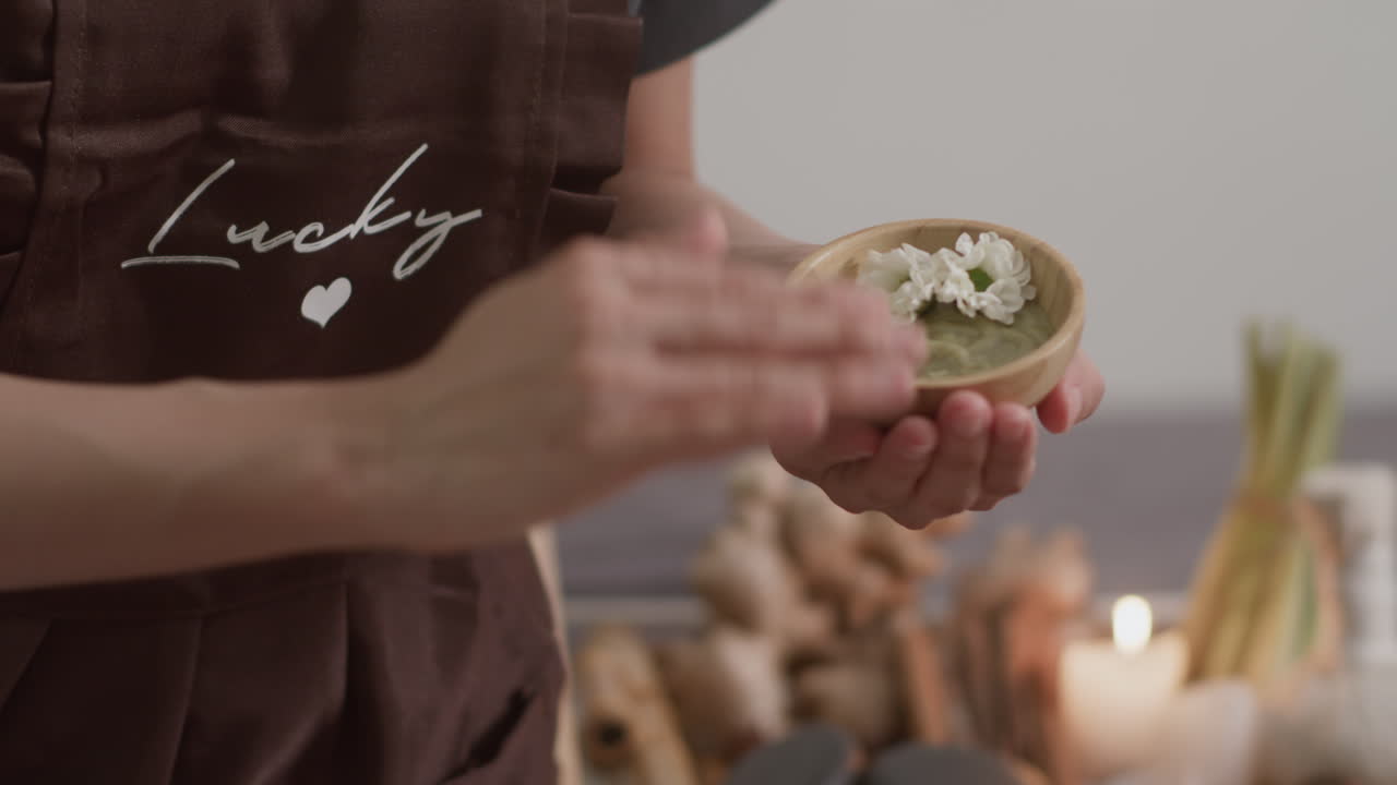 Hands of Spa Salon Manager Moisturizing Back of Client with Clay Mask