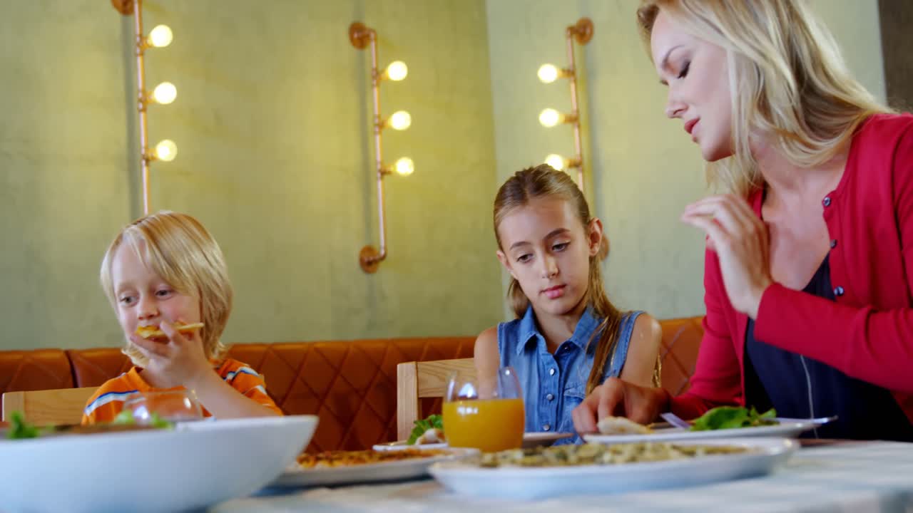 Famiglia che pranza insieme al ristorante 4k