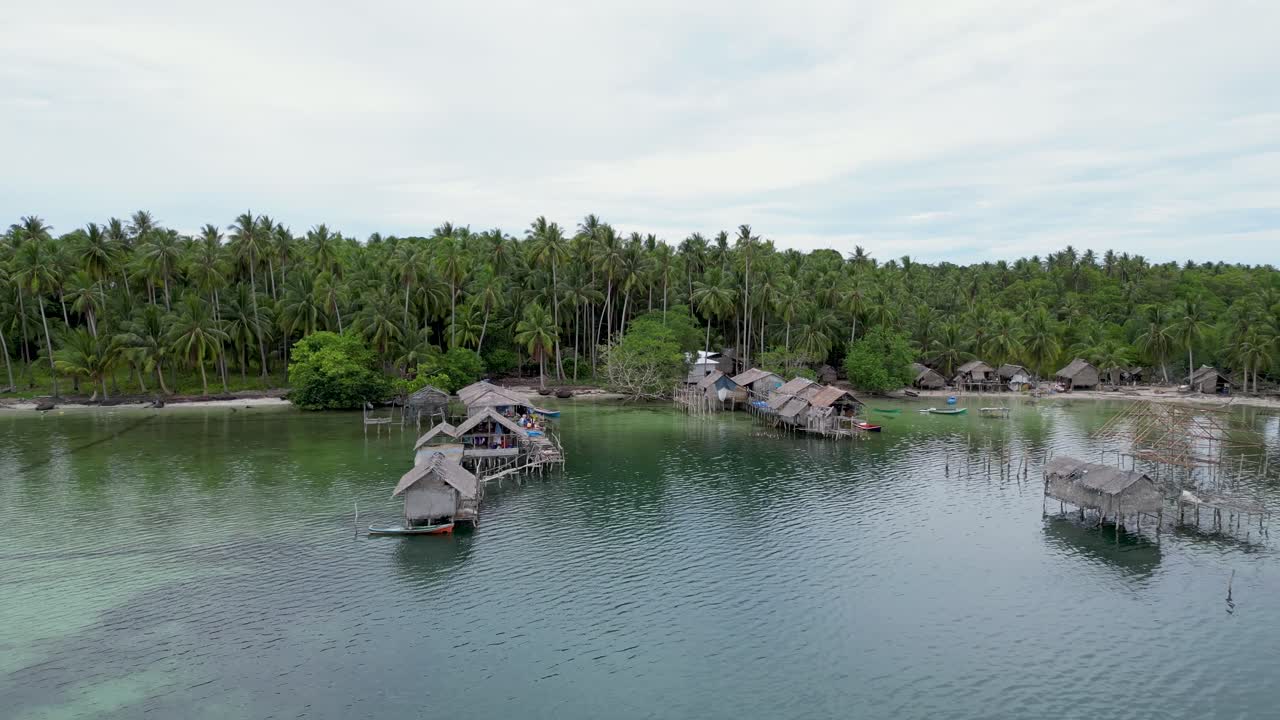 bungalows tropicales en pilotes en el agua de las islas balabac, palmeras detrás