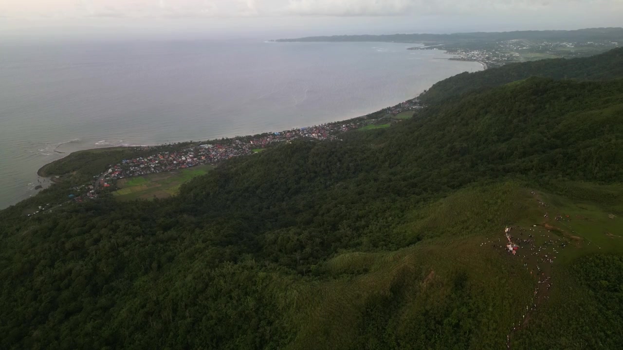 Pemandangan udara yang indah dari Gunung Lantad di Guinobatan, Catanduanes menghadap garis pantai tropis, bukit-bukit berhutan, dan lanskap pulau di sekitarnya