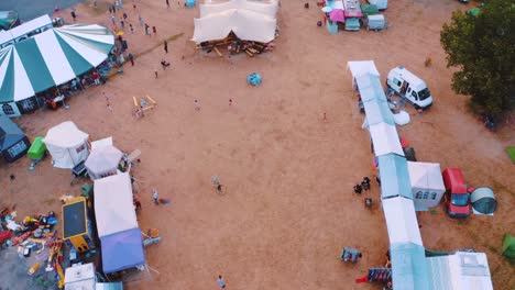 colorful tents set up on a campsite near the forest - aerial shot