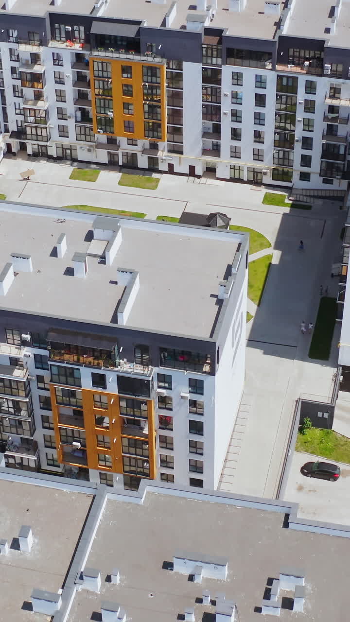 Contemporary apartments in the city complex. Modern residential area with multi-storey buildings. New tall housing apartments. Aerial view. Vertical video