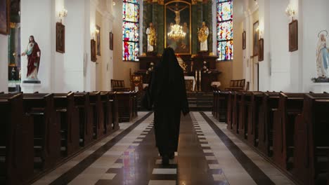 Monja-Caminando-Dentro-De-Una-Iglesia-Católica-Hacia-El-Altar-Sagrado-Visto-Desde-Atrás,-Concepto-De-Personas-Religiosas