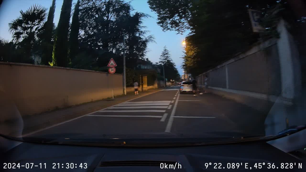 POV a parked car pulls out and drives down narrow streets at dusk, dash cam video