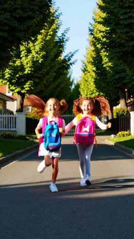 two happy girls with backpacks running down a sunny residential street