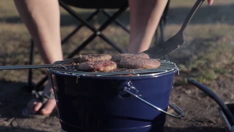 burgers cooking on portable outdoors bbq