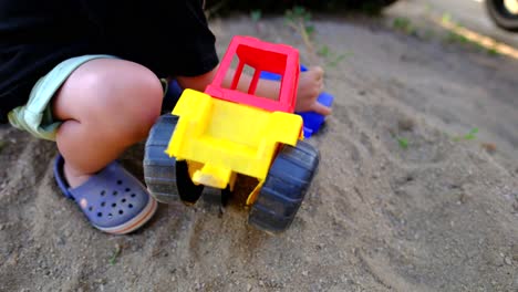 Niño-Jugando-Con-Tierra-Con-Su-Tractor-De-Juguete.