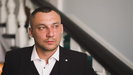 gentleman in black costume and shirt with unbuttoned collar