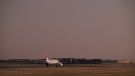 airplane taking off and landing at sunset