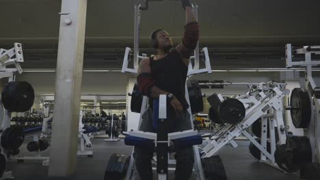 Black-Male-Bodybuilder-Strongman-Athlete-Beginning-To-Lift-Black-Weights-On-Sports-Equipment-in-4K