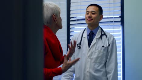 Young-Asian-male-doctor-interacting-with-senior-patient-in-the-clinic-4k