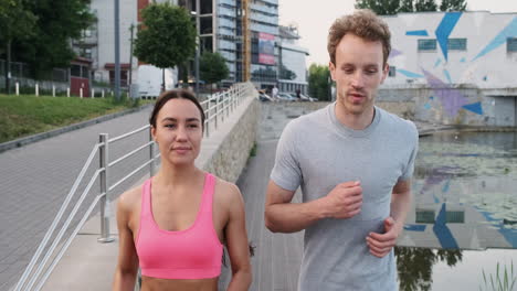 pareja feliz corriendo juntos en la ciudad mientras hablan entre ellos 1