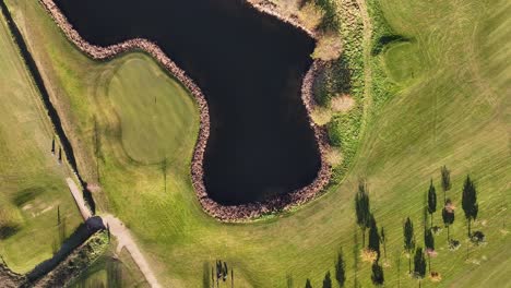 Drone-view-of-an-Irish-Golf-Club-passing-above-a-lake-and-a-fairway