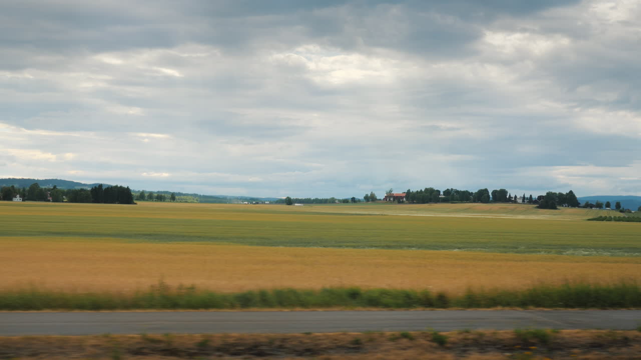 сельский пейзаж в норвегии - из окна видны поля, на которых лежат стога соломы после жатвы