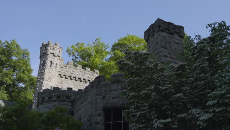 Vista-De-Un-Hermoso-Castillo-De-Piedra-Que-Se-Asoma-Detrás-De-Los-árboles-En-Un-Día-Soleado