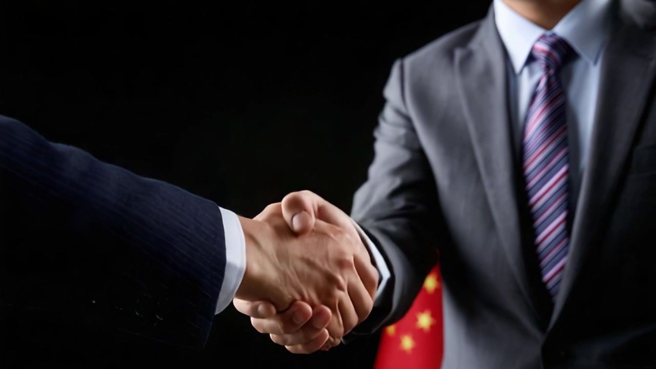 A Professional Handshake Signifying Agreement and Partnership Between Two Individuals in Formal Attire Within a Business Context, Set Against a Simple Dark Background