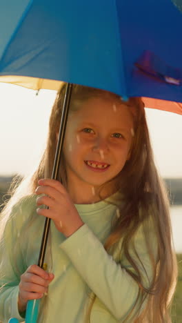 girl hides from rain under parasol in sunlight. child transforms mundane rainy day in playful dance of colors and droplets. warmth among downpour