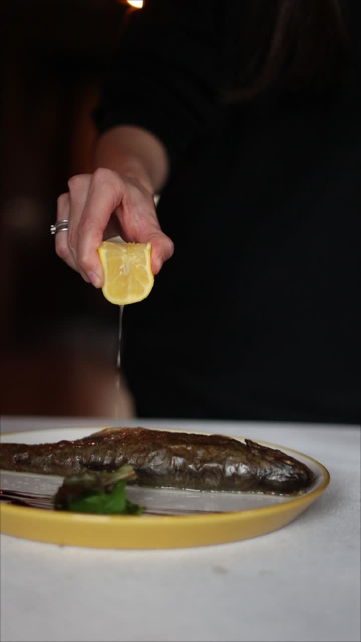 exprimir el limón sobre la trucha a la parrilla