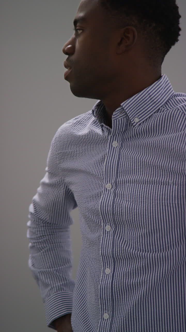 Vertical Video Of Young Man With Mental Health Issues Standing Leaning Against Wall In Office Looking Depressed And Unhappy