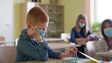 Video-of-bored-boy-sitting-in-a-classroom-during-a-pandemic