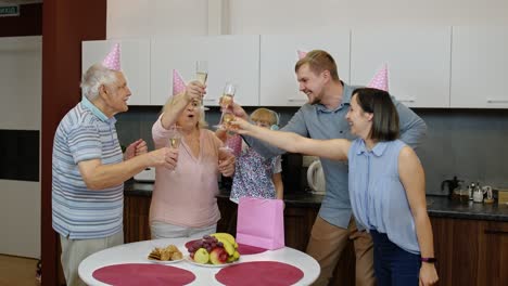 family celebrating a birthday with champagne and cake