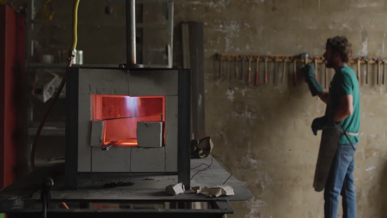 카우카시안 남성 수공이 테이블 위에 클린과 함께 작업실에서 도구를 가져갑니다.