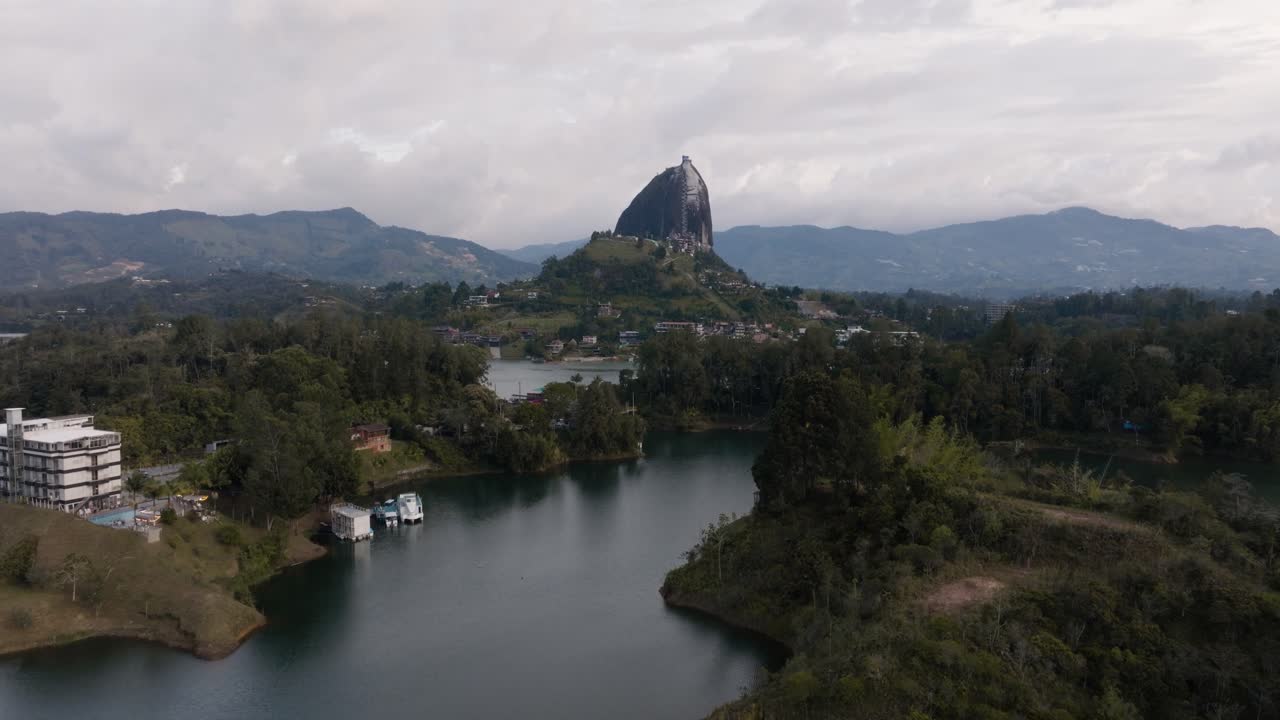 Drone shot of El Peñón de Guatapé (La Piedra Rock) with lakes and mountains on a cloudy day