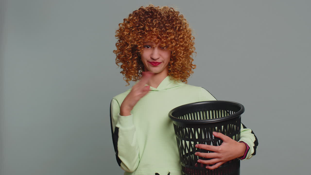 Smiling girl taking off throws out glasses into bin after successful vision laser treatment therapy