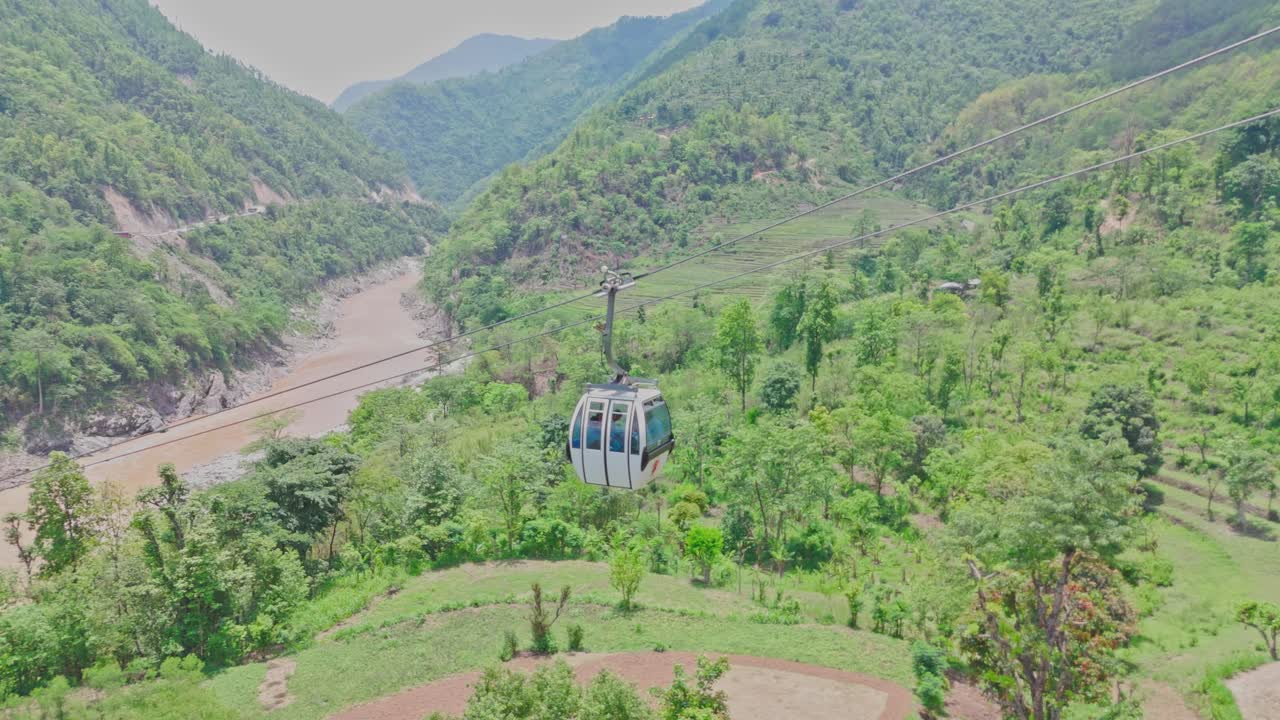 A cable car travels above a flowing river and lush green mountains, offering a stunning view of nature, elevation, and movement. Perfect for themes of travel, exploration, and scenic transportation