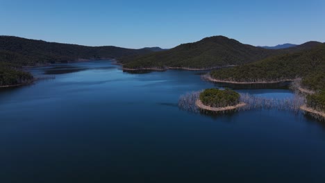 exuberante bosque verde junto a las montañas que rodean las tranquilas aguas de la presa hinze - suministro de agua potable en la región de la costa dorada - embalse en advancetown, queensland, australia