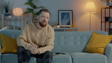 Man Sitting on Couch Watching TV