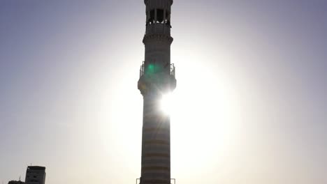 minaret silhouetted by bright sun