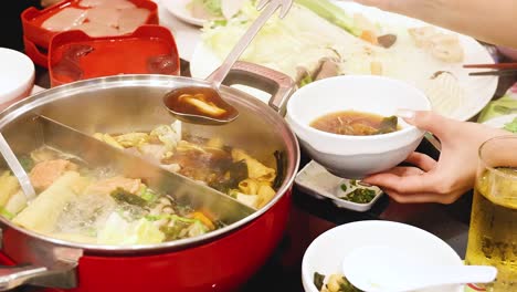 sharing hotpot soup at a dining table